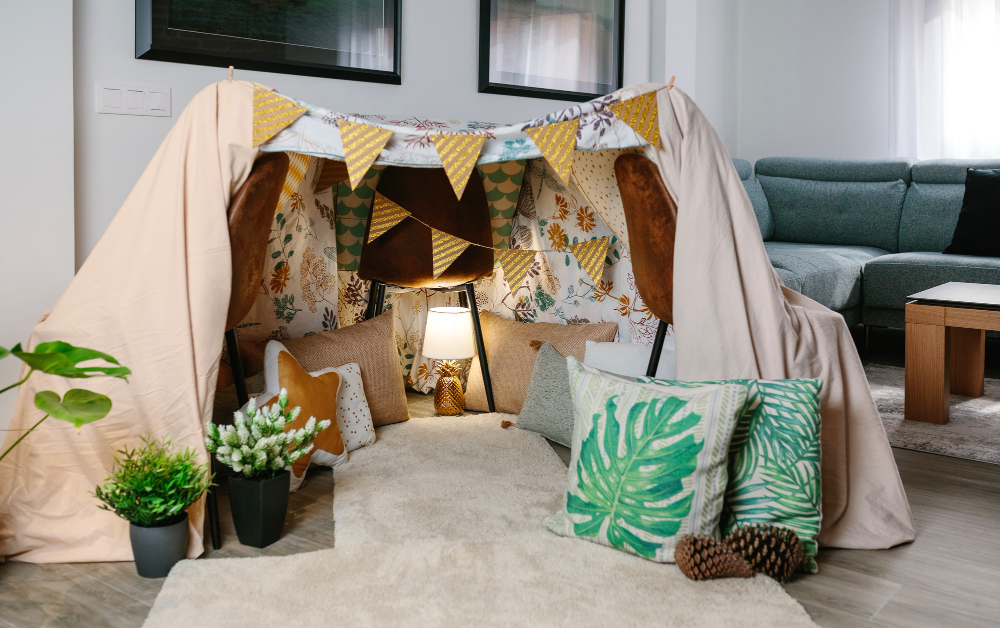 A cozy oasis awaits! Step into the Tented Treasures Baby Shower Ideas, where a tent adorned with pillows and a plush rug invites relaxation in the heart of a room