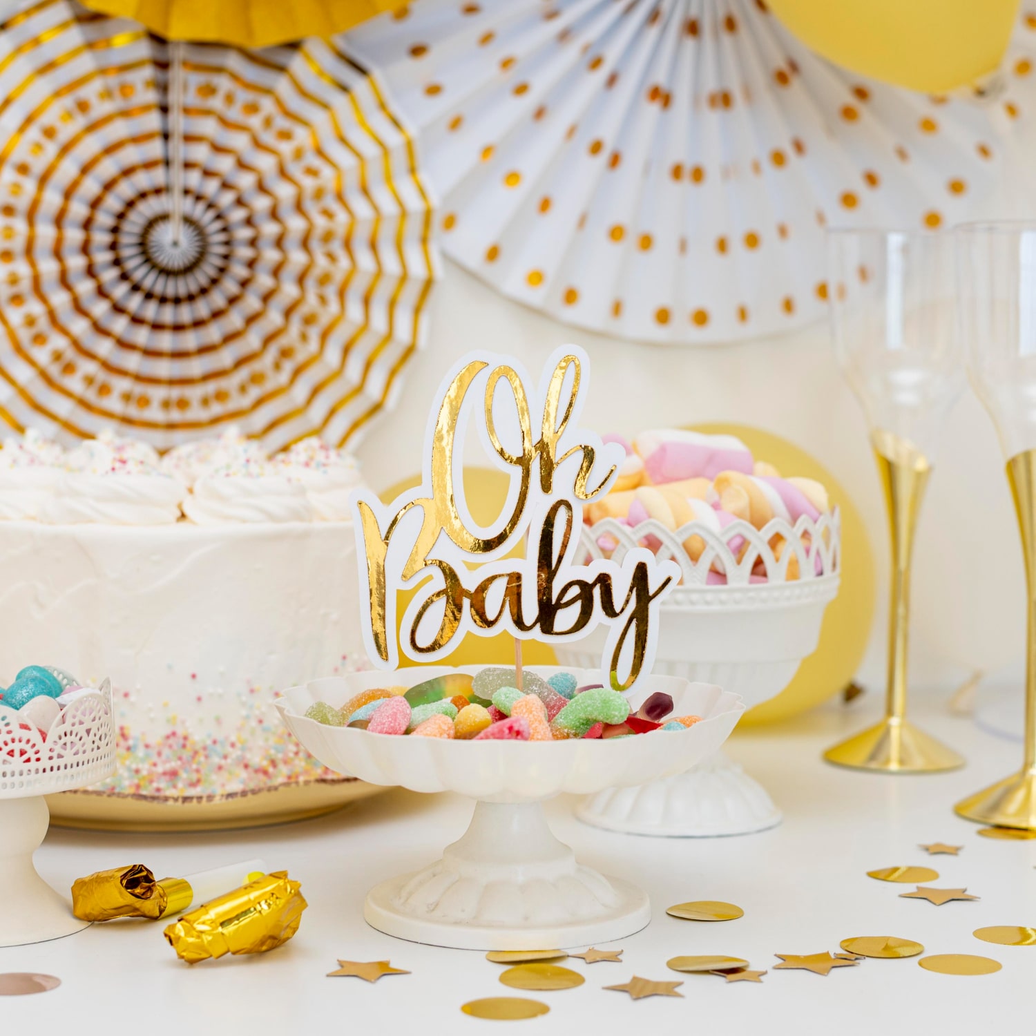 A delightful spread of treats awaits at this Baby Shower! Indulge in a scrumptious cake, delectable cupcakes, and other delightful goodies on a beautifully set table.